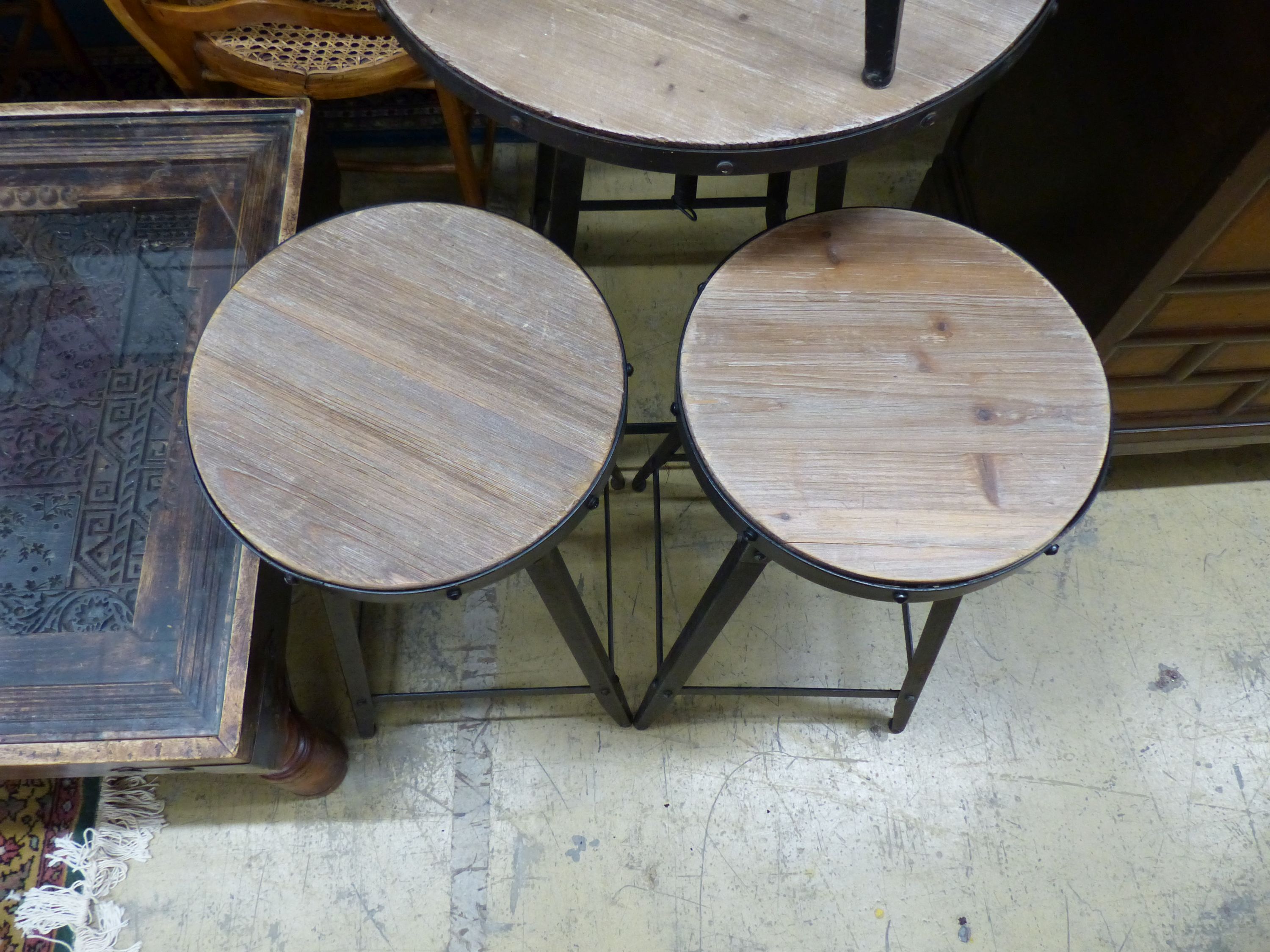 An adjustable wrought iron pub table and three matching telescopic stools